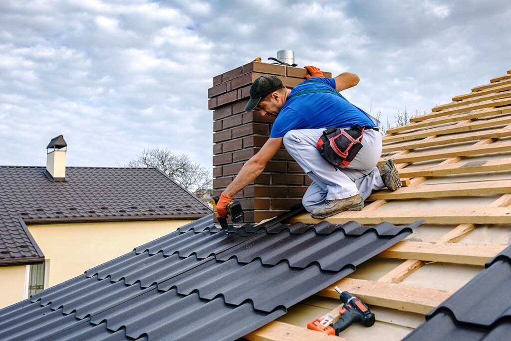 Person using a soft roof rake from the ground to remove leaves from a shingled roof